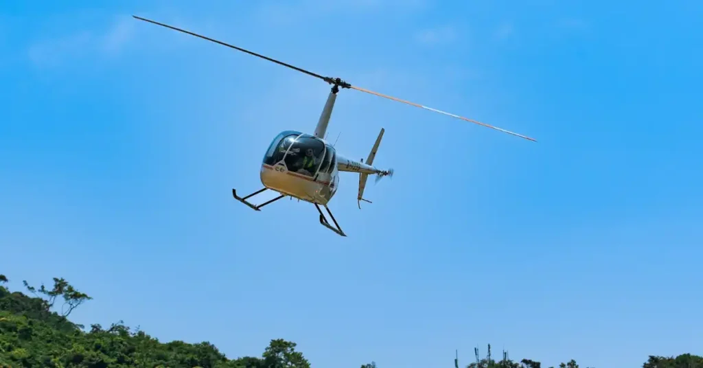 Foto de um helicóptero voando com o azul do céu ao fundo